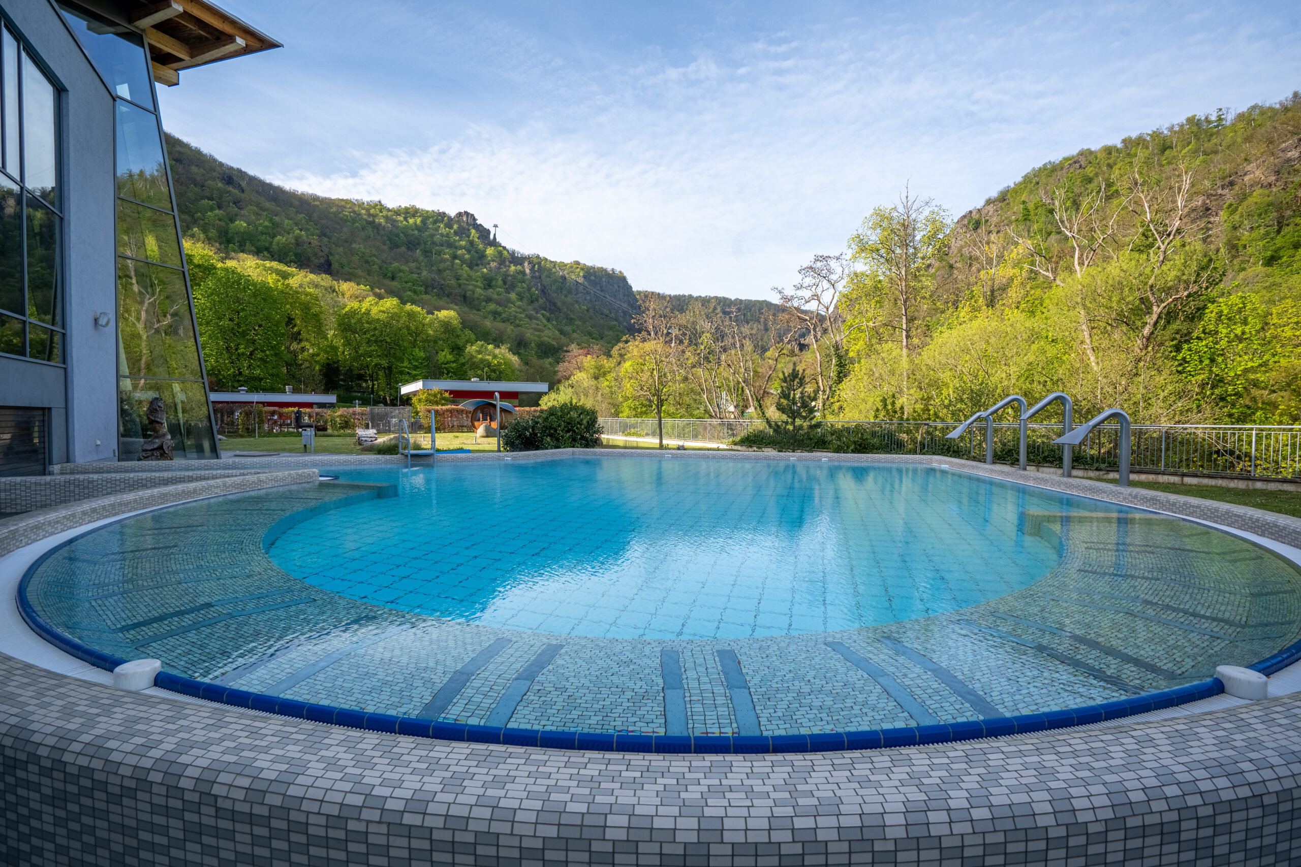 Rundes Au&szlig;enwarmbecken der Bodetal Therme mit Blick auf die Harzberge